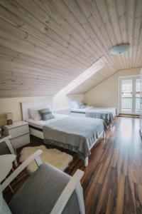 two beds in a room with a wooden ceiling at Väike-Mere Villa in Haapsalu