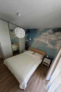 クラクフにあるガーデン コーナーのベッドルーム1室(壁に絵画が描かれた大型ベッド1台付)