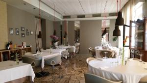 una sala da pranzo con tavoli e sedie bianchi di Hotel Trieste a Pontelongo
