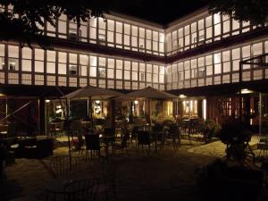 a building with tables and chairs in a courtyard at night at El Montero in Soto