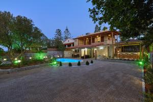 a large house with a swimming pool in front of it at Villa Feronia in Hersonissos