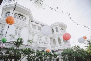 een wit gebouw met kleurrijke papieren lantaarns ervoor bij Villa Song Saigon in Ho Chi Minh-stad
