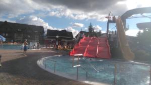 a water park with a red slide in the water at Donovaly AD Kamzík - apartmán 47 in Donovaly