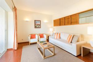 a living room with a white couch and two chairs at Apartamentos Turisticos Pinhal Da Marina in Vilamoura +69 photos