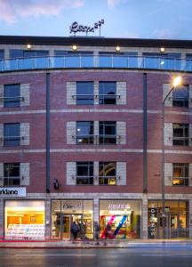 a large brick building on a street with a street light at Roomzzz Leeds City in Leeds