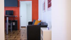 a living room with a black couch and an orange wall at Italianway-Lodi 78 in Milan