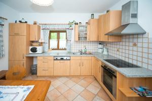 Strohmarkt的住宿－Oberbach，厨房配有木制橱柜和炉灶烤箱。