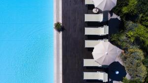 an overhead view of a patio with umbrellas and a pool at Hotel Dei Pini in Alghero
