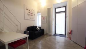 - un salon avec un canapé noir et une fenêtre dans l'établissement Italianway-Eustachi, à Milan