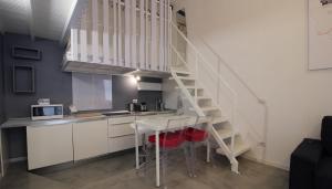 une cuisine avec un escalier, une table et des chaises dans l'établissement Italianway-Eustachi, à Milan