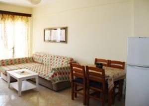 een woonkamer met een bank en een tafel bij Tarace sea view apartment in Sarandë