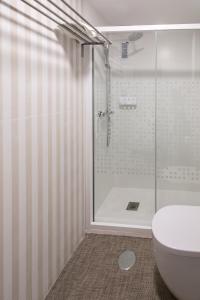 a bathroom with a glass shower and a toilet at Pension Venecia in Pinto