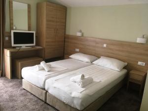a bedroom with two beds with white towels on them at Apartments Dalmatinka in Neum
