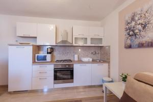 a kitchen with white cabinets and a stove at IRIS Room & Apartment in Slunj