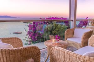 a patio with chairs and tables and a view of the water at Hotel Dei Pini in Alghero