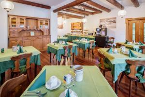a dining room with green tables and chairs at Hotel Al Larin in Cortina dʼAmpezzo