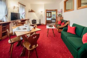 salon z zieloną kanapą i stołem w obiekcie Hotel Al Larin w mieście Cortina dʼAmpezzo