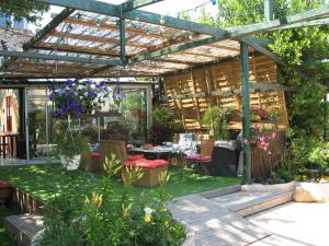 un jardin avec une pergola, une table et des chaises dans l'établissement La Maison de Vérotte, à Claira