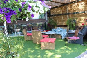 - une terrasse avec une table, des chaises et des fleurs dans l'établissement La Maison de Vérotte, à Claira