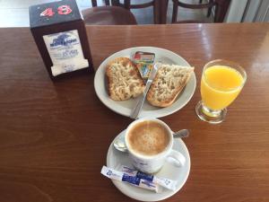 una mesa con dos platos de comida y una taza de café en Pensión La Ola, en Grao de Castellón