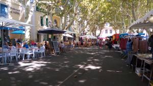 セリニャンにあるT2 à Sérignan Héraultのテーブルと椅子、座席の人々が並ぶ通り