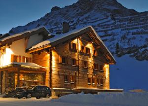 a log cabin with a car parked in front of it at Bentleys House MOUNTAIN Residence in Zürs am Arlberg