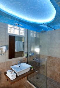 Un baño con lavabo y ducha de cristal. en Villa Feronia, en Hersonissos