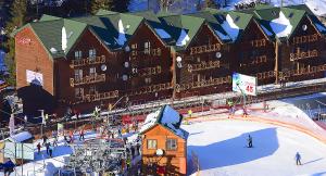 ein Gebäude mit einer Skipiste im Schnee in der Unterkunft ZimaSnow Ski & Spa Club in Bukowel