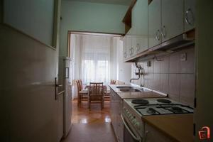 a kitchen with a stove and a dining room at Apartment Buzarovski in Skopje