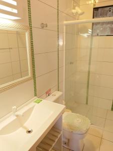 um banheiro com chuveiro, vaso sanitário e pia em Pousada Suites do Santinho em Florianópolis