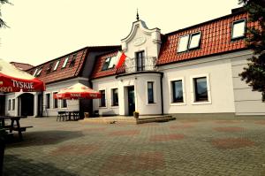 duży biały budynek z wieżą zegarową w obiekcie Hotel Wielkopolanka w mieście Środa Wielkopolska