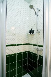 y baño con ducha y azulejos blancos y negros. en O'Hara, en Voronezh