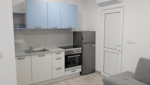 a kitchen with white cabinets and a stainless steel refrigerator at Stars Palace Vodice in Vodice