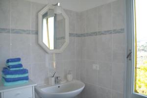 a white bathroom with a sink and a mirror at La casa del Prussiano in Diano Castello +28 photos