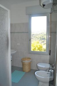 a bathroom with a window and a toilet and a sink at La casa del Prussiano in Diano Castello