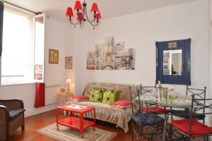 uma sala de estar com um sofá e uma mesa em La Mignonette em Épernay