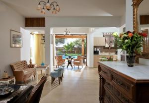 Una cocina y una sala de estar con mesa y sillas. en Villa Feronia, en Hersonissos