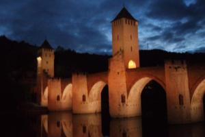 un château avec deux tours et un pont la nuit dans l'établissement Le Balcon des Jasses, à Espère