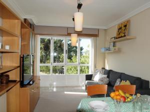 ein Wohnzimmer mit Sofa und Tisch in der Unterkunft Apartamento Compostela Playa in Vilagarcia de Arousa