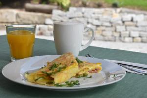 un piatto di cibo e una tazza di succo d'arancia di 1st Republic Villa - Adults only a Cesky Krumlov