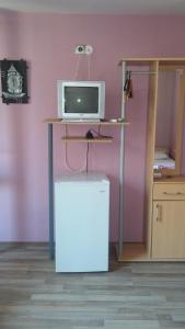 a room with a desk with a tv and a refrigerator at Comfort Guest Rooms in Pleven +17 photos