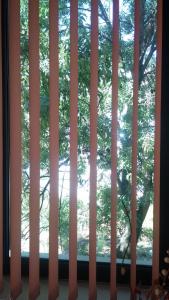 a window with blinds in a room with trees at Comfort Guest Rooms in Pleven