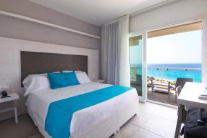 a bedroom with a bed and a view of the ocean at BV Kalafiorita Resort in Zambrone