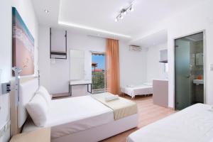 a white bedroom with two beds and a bathroom at Asteria Studios in Potos +29 photos