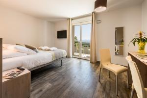 a bedroom with a bed and a large window at Hotel du Grand Parc in Gex