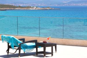 a balcony with a table and chairs and the ocean at Hotel Dei Pini in Alghero