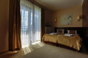 sypialnia z łóżkiem i dużym oknem w obiekcie Willa Port Rezydencje 310 w Ostródzie