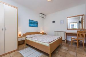 a bedroom with a bed and a desk and a chair at Guesthouse Casa Nova in Poreč
