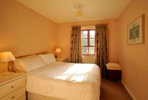 1 dormitorio con cama blanca y ventana en Pinewood Lodge Guest House, en Omagh