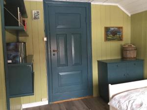 a blue door in a room with a bedroom at Staurset gård in Mittet